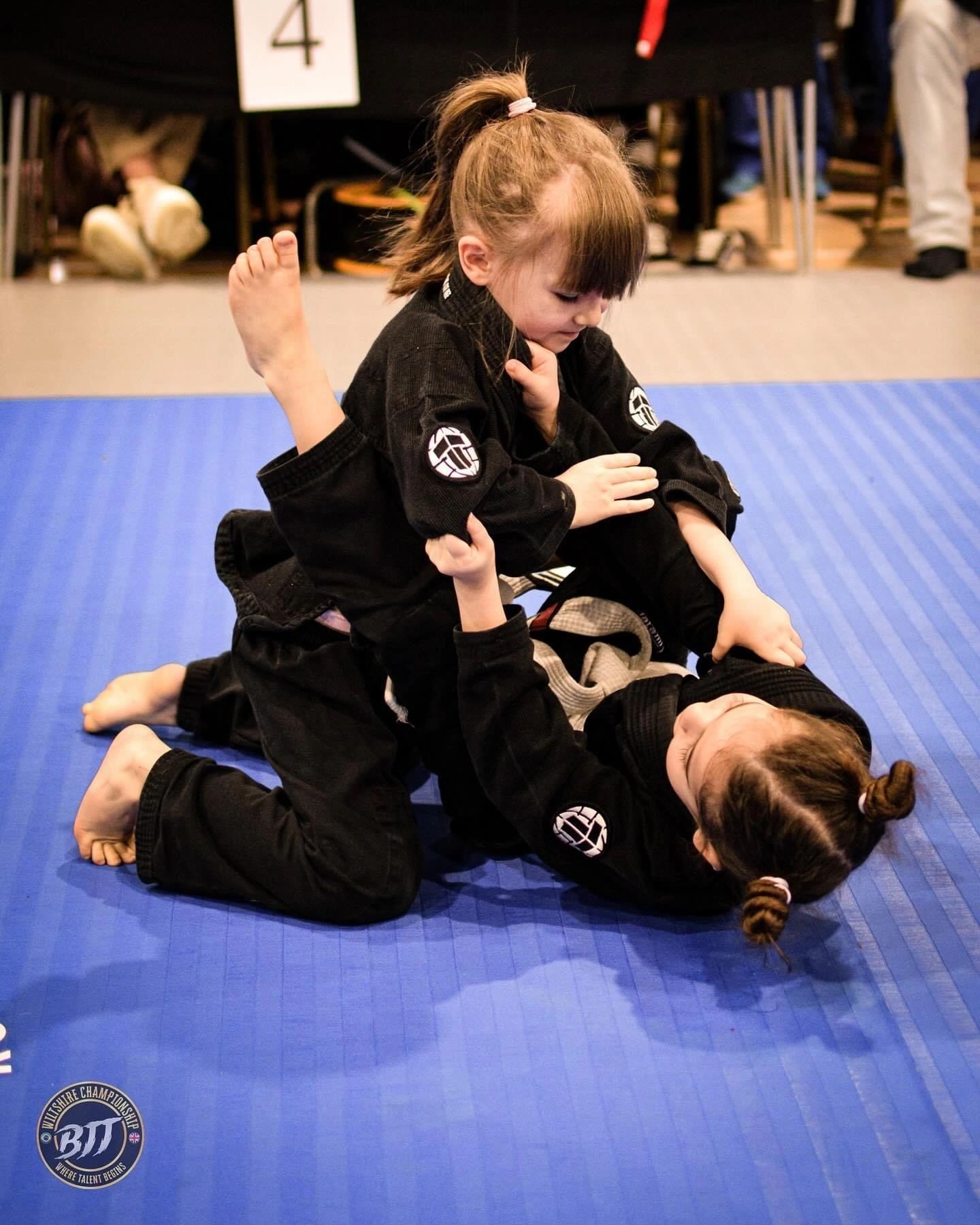 Doi copii exersează o poziție de BJJ pe saltea